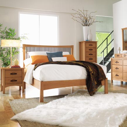Wooden bed with matching nightstand, dresser, and chest of drawers in a stylish bedroom.