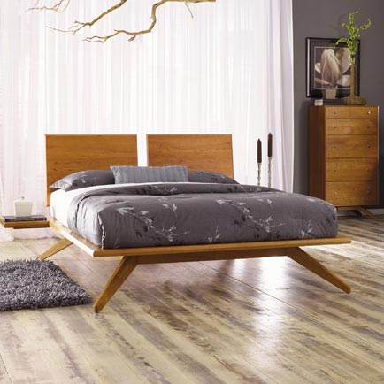 A modern bedroom with wooden floors and a wooden bed.
