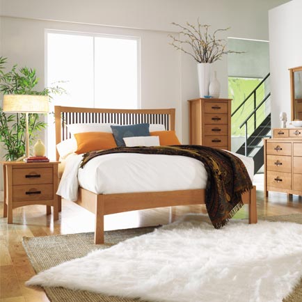 A bedroom with a bed, dresser, and mirror.