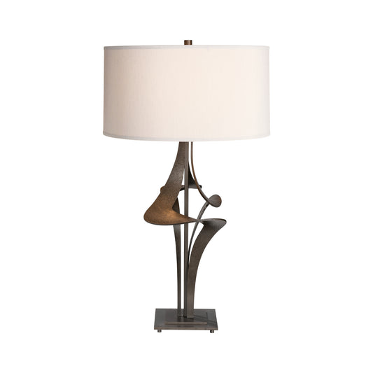 Handcrafted Antasia #2 Table Lamp by Hubbardton Forge featuring an abstract bronze base and white shade, showcasing artisanal American craftsmanship.