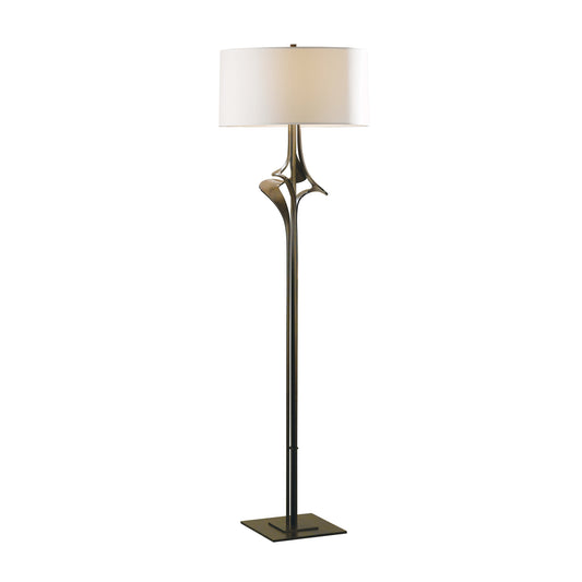 Hubbardton Forge Antasia Floor Lamp featuring a white drum shade, metallic accents, and a sturdy square base, designed for both elegance and durability.