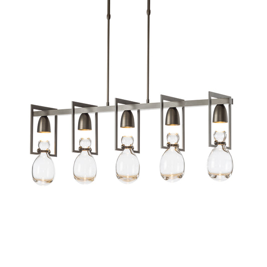 Modern Apothecary Pendant chandelier by Hubbardton Forge featuring 5 hand-blown glass pendants in sleek metal frames on 3 suspended rods.
