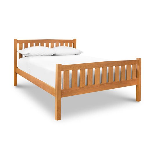 Vermont Furniture Designs Bennington Bed with high footboard and vertical slats in cherry or walnut, shown with white bedding and two pillows.