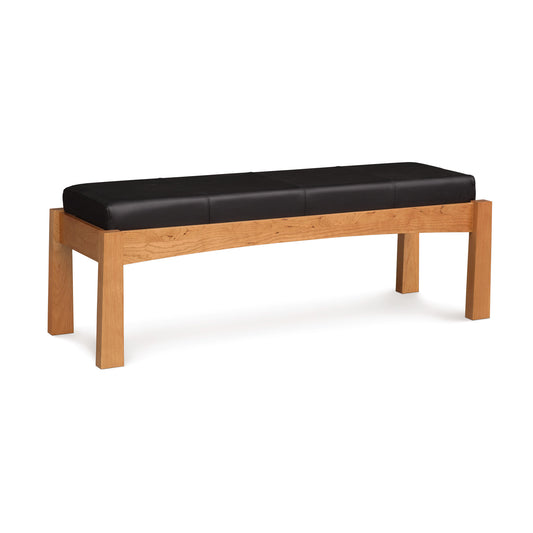Berkeley Upholstered Bench by Copeland Furniture with a black cushioned seat and cherry wood legs, highlighting the elegant design and fine craftsmanship.