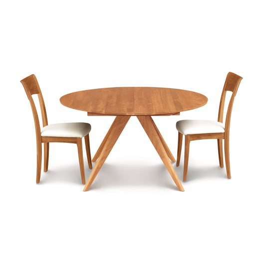 Catalina Round Extension Table by Copeland Furniture with matching custom wooden chairs, highlighting fine craftsmanship and natural wood tones.