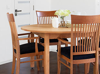 A dining room with a wooden table and chairs.
