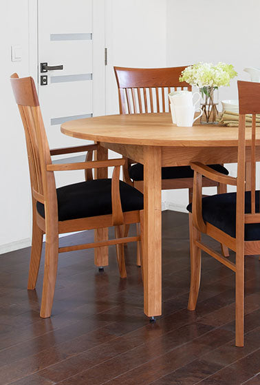 A wooden dining room table with four chairs.
