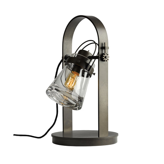 Erlenmeyer Table Lamp by Hubbardton Forge, modern steampunk design, curved metal frame, glass shade with visible bulb and black cord.