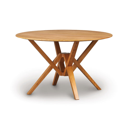 Exeter Round Solid Top Dining Table by Copeland Furniture with intersecting legs, crafted from sustainable hardwoods.