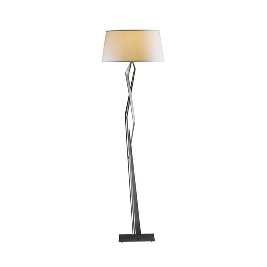 Facet Floor Lamp by Hubbardton Forge with twisted metal base and cream drum shade, highlighting its handcrafted elegance. Perfect balance of modern design and artisanal craftsmanship.
