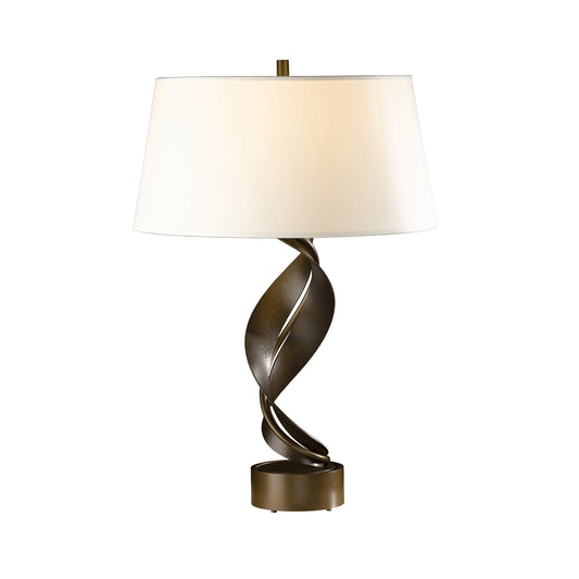 Hubbardton Forge Folio Table Lamp with twisted bronze base and wide white lampshade.