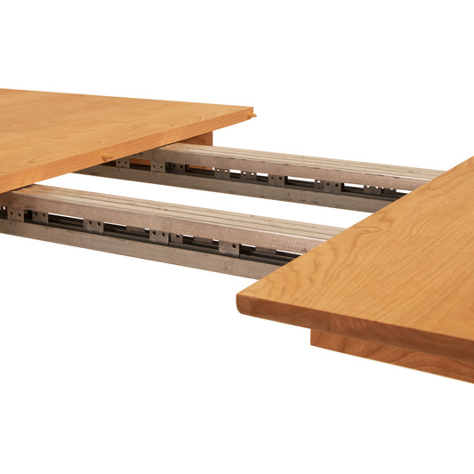 Heartwood Shaker Extension Dining Table by Vermont Furniture Designs, partially extended to reveal the smooth metal extension rails between table sections.