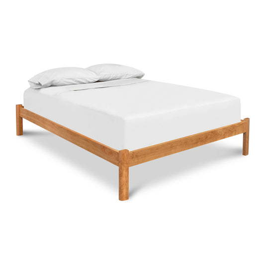 Minimalist Heartwood Shaker Studio-Style Platform Bed with wooden frame and white bedding by Vermont Furniture Designs.
