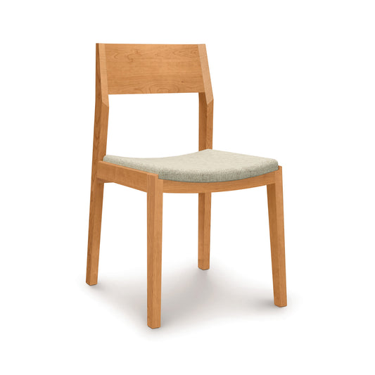 Iso Chair by Copeland Furniture crafted from sustainably sourced hardwoods with a light gray cushioned seat and modern silhouette.