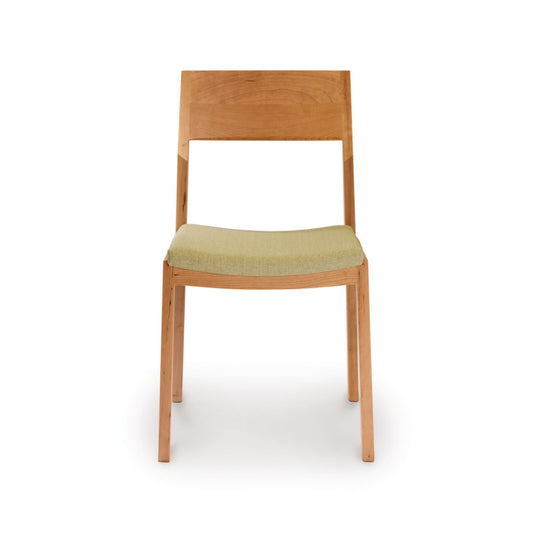 Iso Chair by Copeland Furniture crafted from solid cherry wood with a light green upholstered seat, highlighting its sleek design and fine craftsmanship.