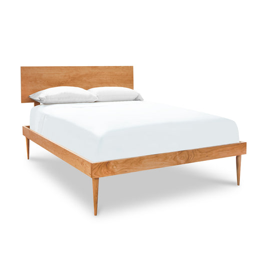 Larssen Bed by Vermont Furniture Designs with a handcrafted wooden frame and headboard, elegantly styled with white sheets.