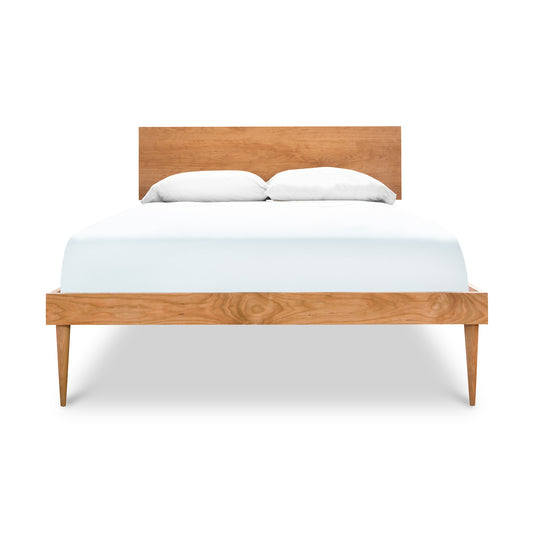 Larssen Bed by Vermont Furniture Designs, showcasing a handcrafted wooden frame with a white mattress and two pillows.