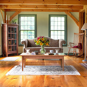 A living room with wood floors and a rocking chair.