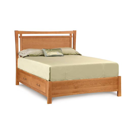 Copeland Monterey Storage Bed in cherry wood with underbed drawers, shown with light green bedding and two pillows.