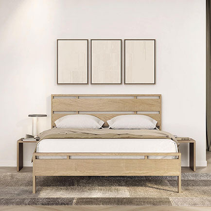 Wooden bed frame with two pillows and a neutral bedspread, featuring minimalist design.