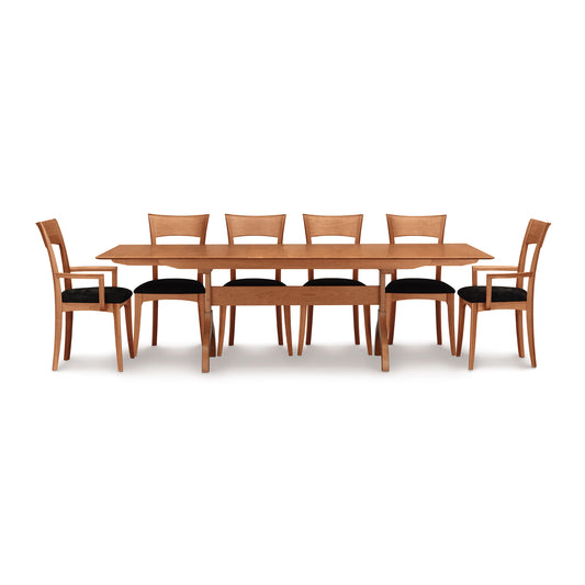 Copeland Furniture Sarah Shaker Trestle Extension Table with eight matching chairs featuring black cushions, showcasing fine American craftsmanship.