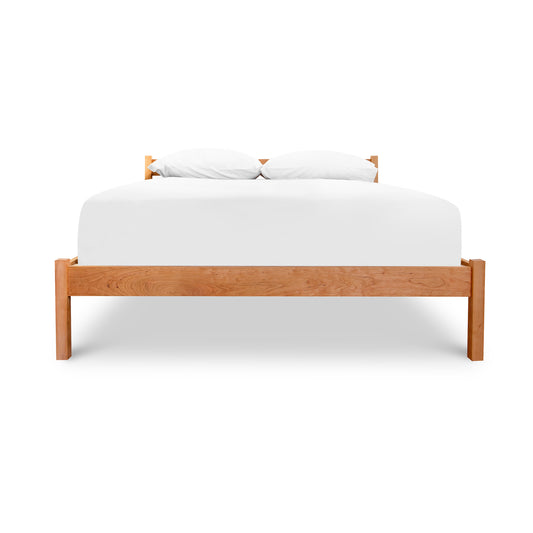 Vergennes Platform Bed by Vermont Furniture Designs, showcasing its minimalist solid wood craftsmanship with white bedding and pillows.