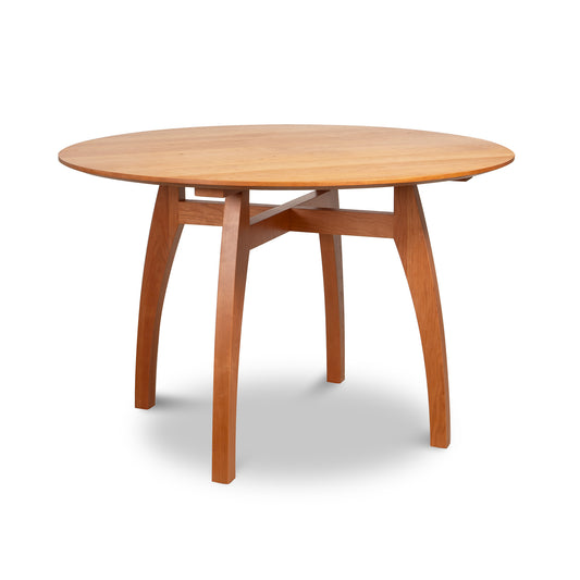 Lyndon Furniture Vermont Modern Round Solid Top Pedestal Table with four curved legs and crossbar, crafted in solid wood.