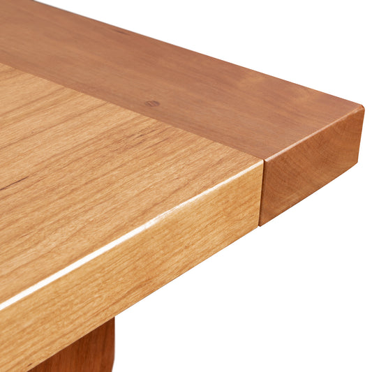 Corner detail of Vermont Shaker Solid Top Harvest Table by Maple Corner Woodworks, showcasing the smooth edge and natural cherry grain and texture.
