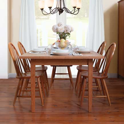 A dining room with a wooden table and chairs.